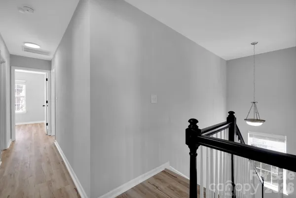 a view of a hallway with wooden floor and stairs