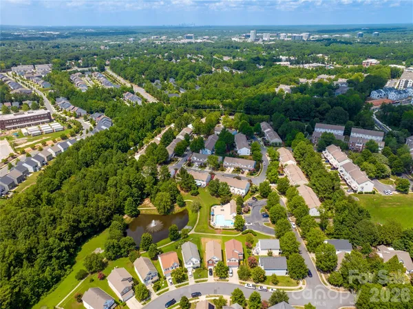 an aerial view of residential houses with outdoor space and trees