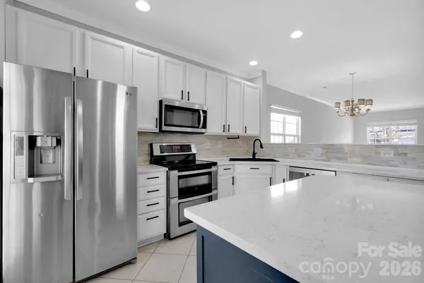 a kitchen with stainless steel appliances a refrigerator stove microwave and sink