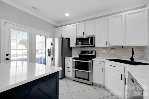 a kitchen with stainless steel appliances a stove sink microwave refrigerator and cabinets