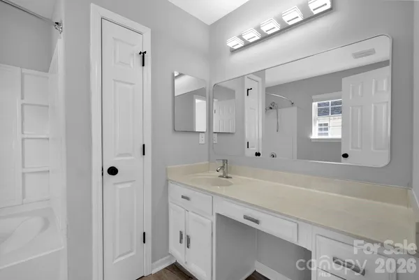 a spacious bathroom with a sink a mirror and a shower