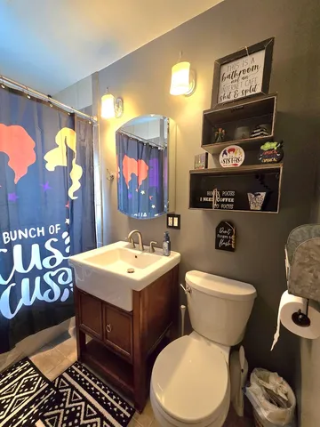 a bathroom with a toilet a sink and a mirror