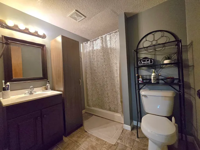 a bathroom with a toilet a sink and shower