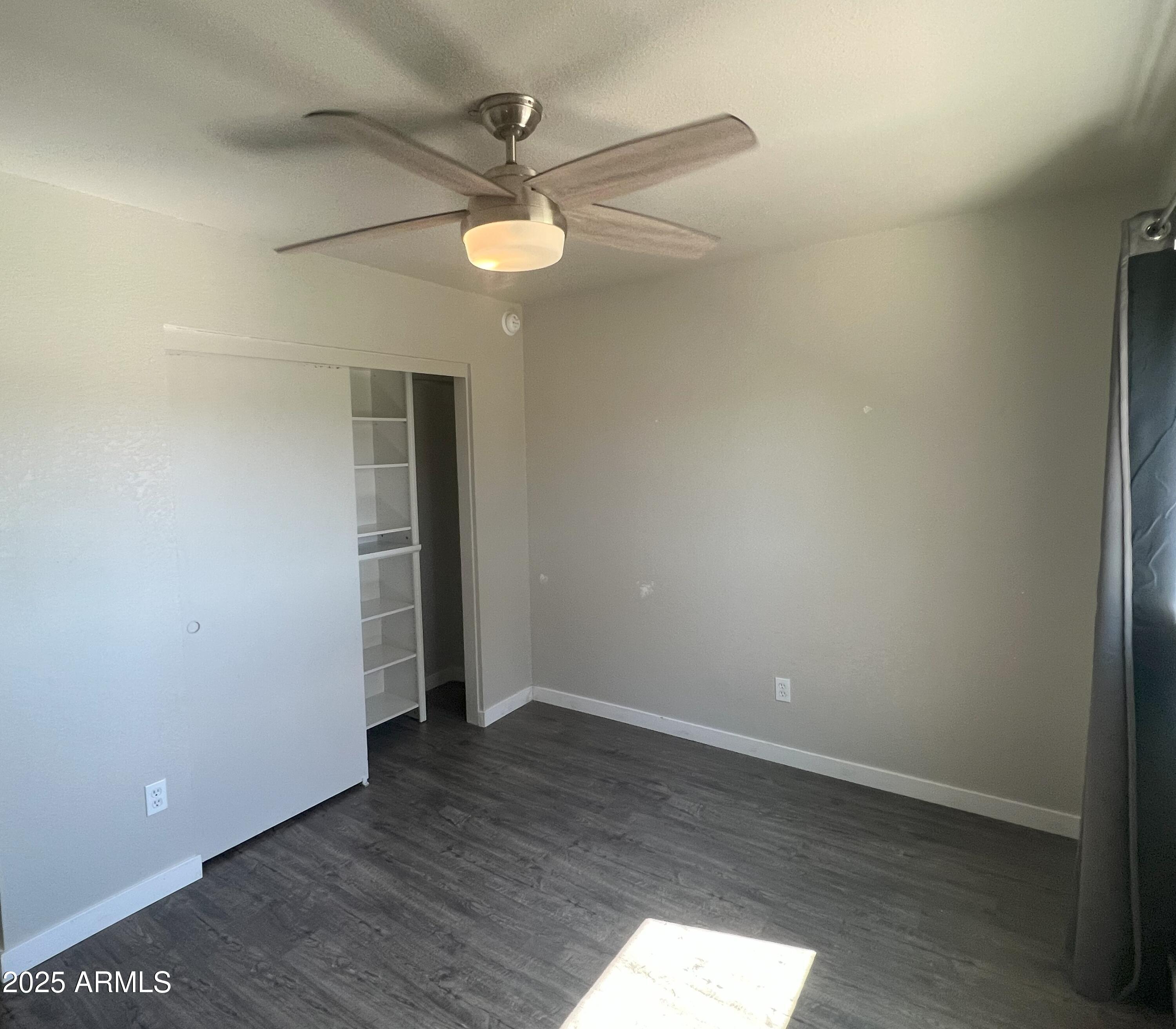 4011 East Charter Oak Road Phoenix, AZ 85032 - Photo 15 of 31 an empty room with wooden floor and ceiling fan