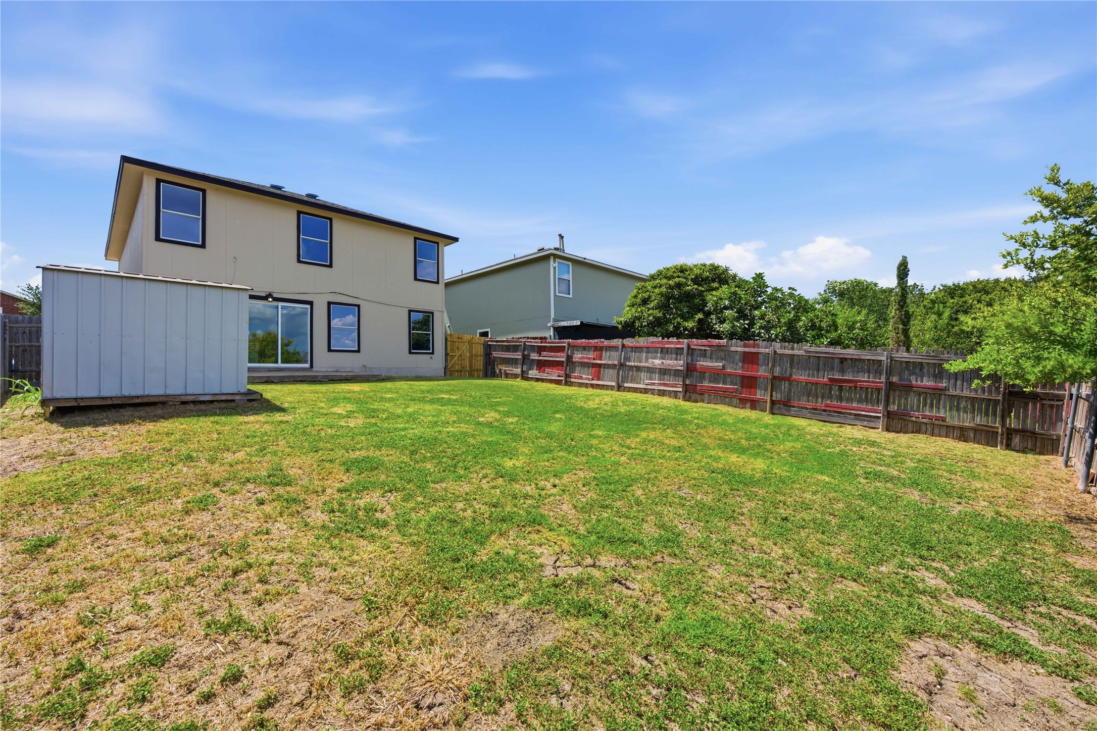 6917 Panda Royle Drive Del Valle, TX 78617 - Photo 23 of 23 A spacious, enclosed backyard offers ample green space and a practical storage shed.
