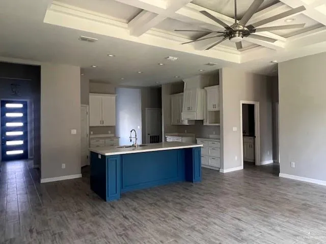 a view of kitchen with stainless steel appliances granite countertop a sink cabinets and wooden floor