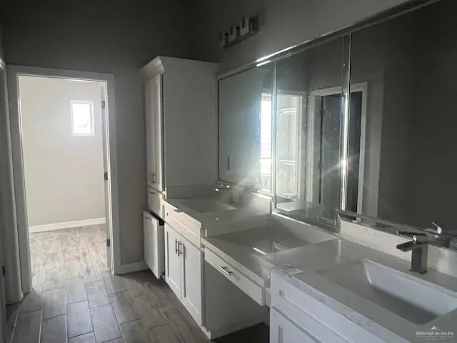 a bathroom with double vanity and a mirror