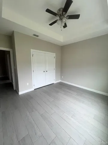 an empty room with a ceiling fan and window