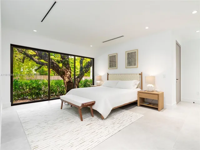 a spacious bedroom with a large bed and a large window