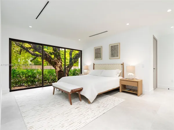 a spacious bedroom with a large bed and a large window