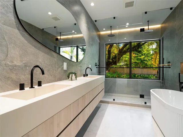 a bathroom with a large tub a sink and window