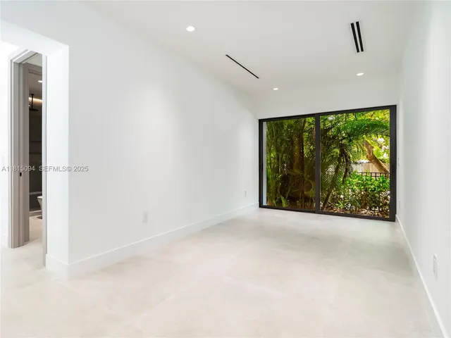 a view of a big room with wooden floor and windows