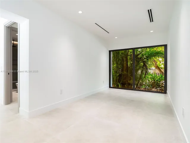 a view of a big room with wooden floor and windows