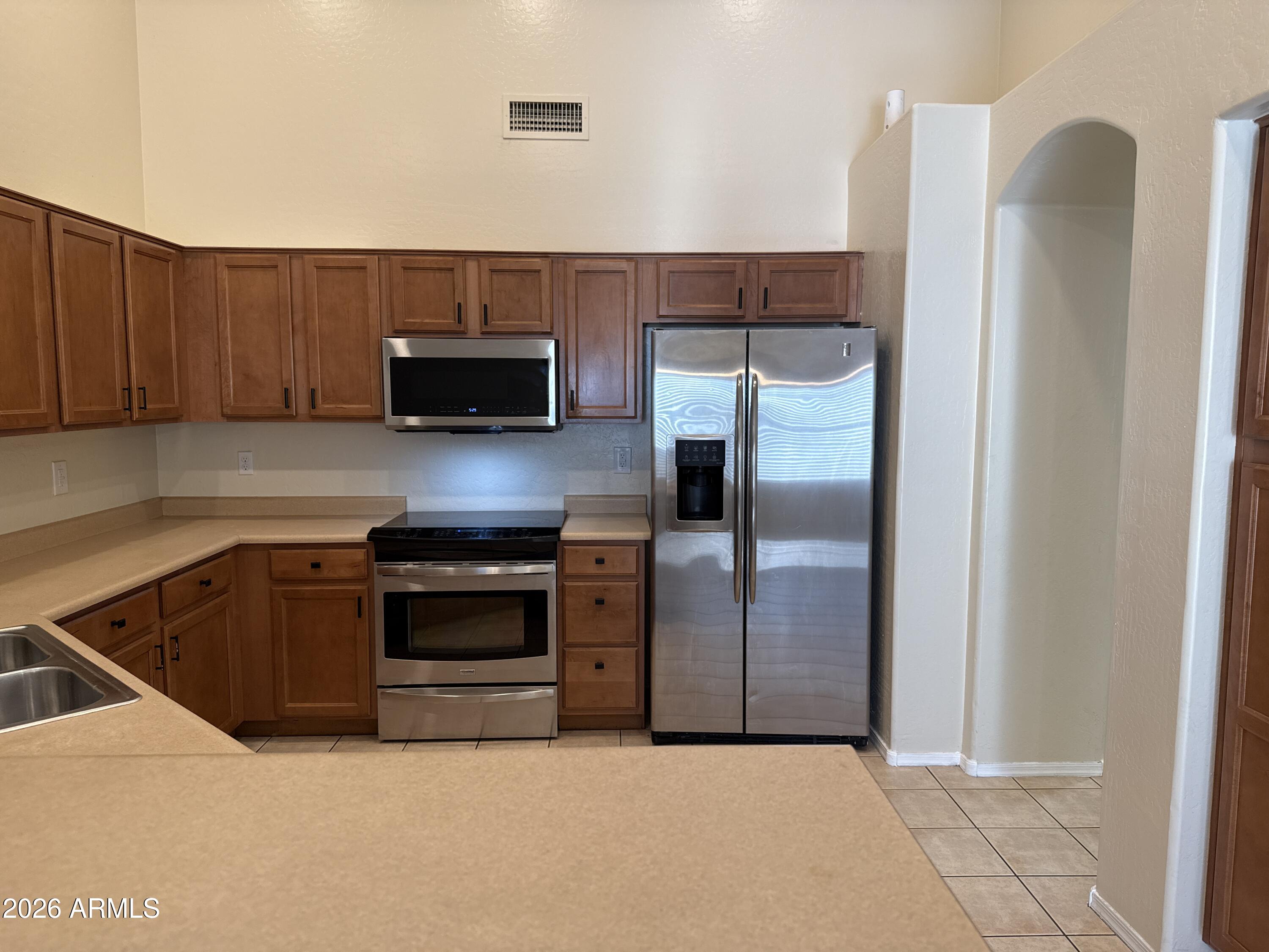 9630 West Reno View Drive Peoria, AZ 85345 - Photo 4 of 21 a kitchen with granite countertop a refrigerator and a stove