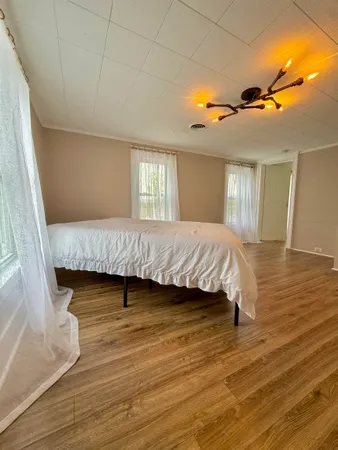 a bedroom with a bed and wooden floor