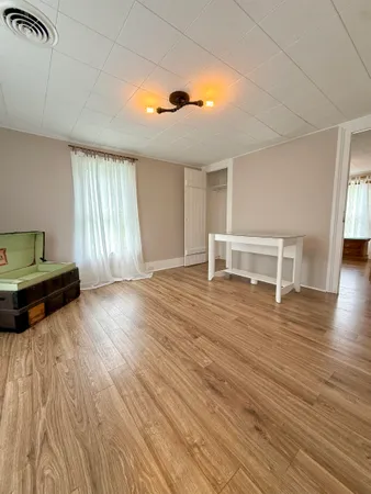 a view of a bedroom with furniture and wooden floor