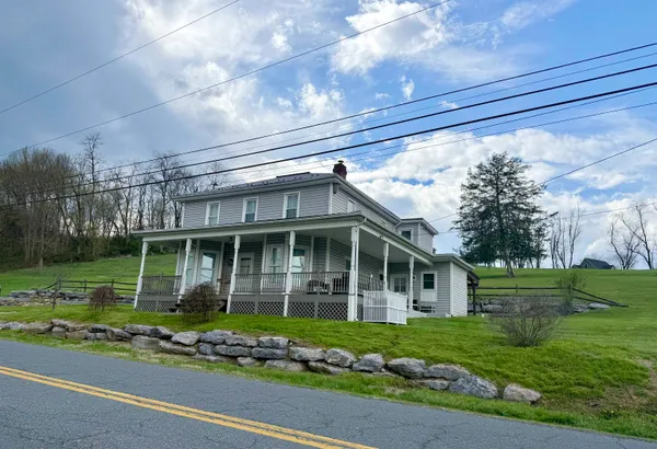 a view of a house with a yard and sitting area