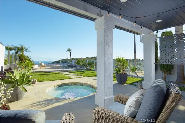 a view of a swimming pool with a couches chairs and table in patio