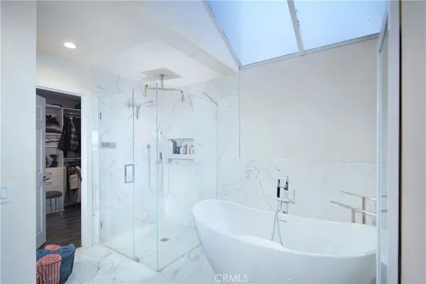a white bath tub sitting next to a shower