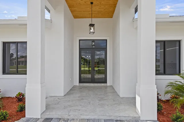 a kitchen with stainless steel appliances a sink a stove a refrigerator a center island and chairs