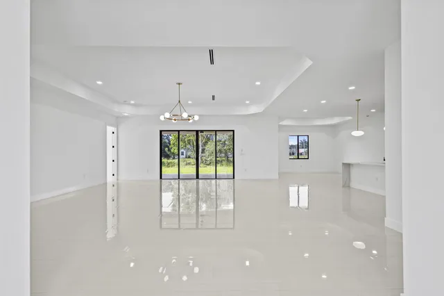 a large white kitchen with a large island oven a sink stainless steel appliances and cabinets