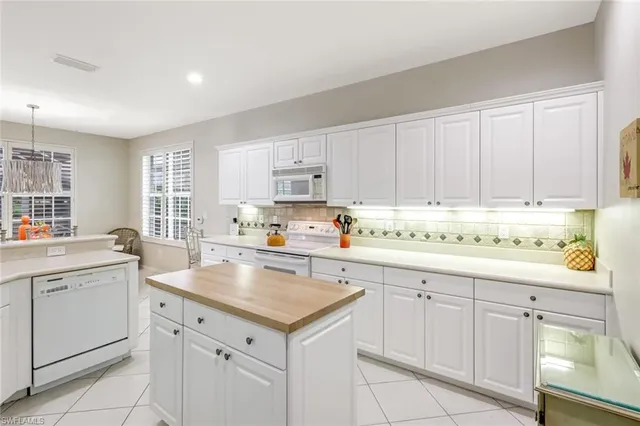 a kitchen with white cabinets and white appliances