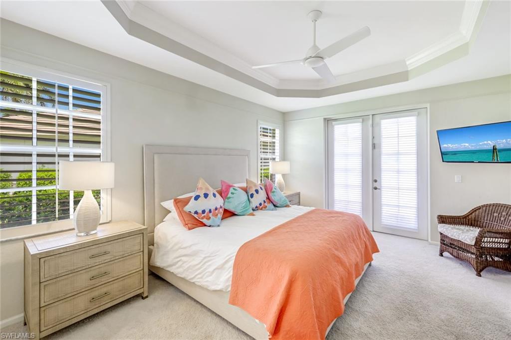 23045 Tree Crest Court Estero, FL 34135 - Photo 14 of 46 Carpeted bedroom featuring a raised ceiling, access to exterior, ceiling fan, french doors, and crown molding