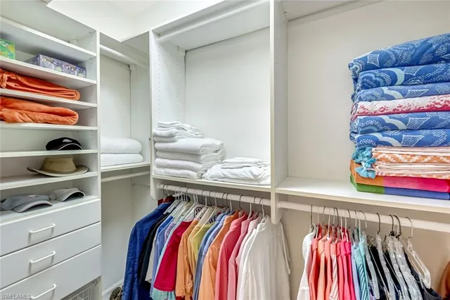 a view of walk in closet with clothes and shoes