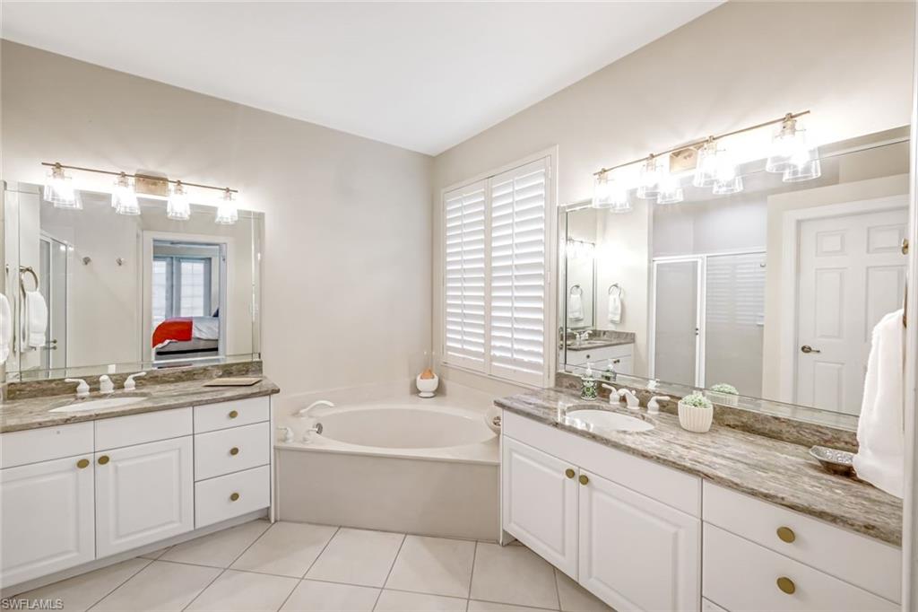 23045 Tree Crest Court Estero, FL 34135 - Photo 17 of 46 Full bath with a shower stall, two vanities, ensuite bath, a bath, and light tile patterned flooring