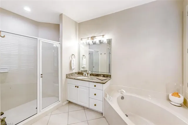 a bathroom with a tub a sink and a large mirror