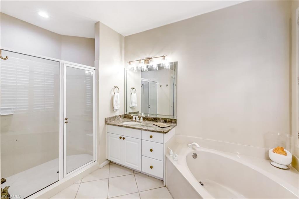 23045 Tree Crest Court Estero, FL 34135 - Photo 18 of 46 Bathroom with vanity, a stall shower, light tile patterned floors, and a garden tub