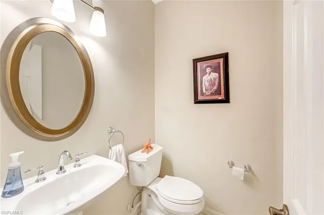 a bathroom with a toilet a sink and a mirror