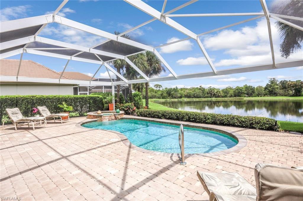 23045 Tree Crest Court Estero, FL 34135 - Photo 33 of 46 View of pool featuring a pool with connected hot tub, a sunroom, a lanai, a water view, and a patio area