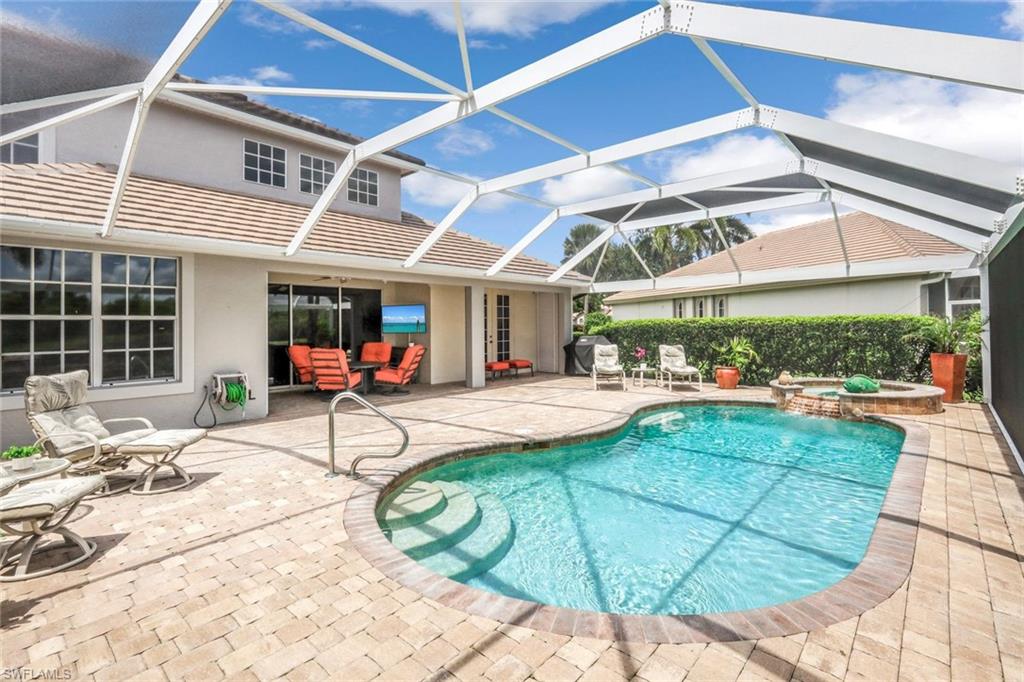 23045 Tree Crest Court Estero, FL 34135 - Photo 34 of 46 View of swimming pool featuring a patio area, a sunroom, glass enclosure, and a pool with connected hot tub