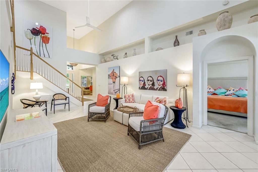 23045 Tree Crest Court Estero, FL 34135 - Photo 7 of 46 Living area with light tile patterned flooring, a high ceiling, and stairway