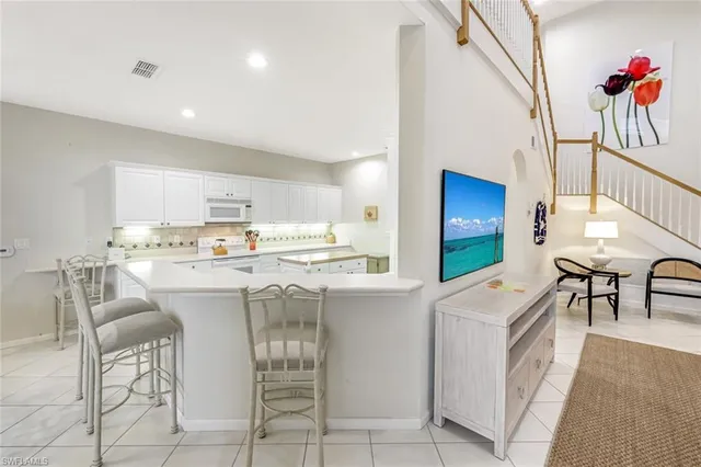 a kitchen with kitchen island a sink counter and chairs