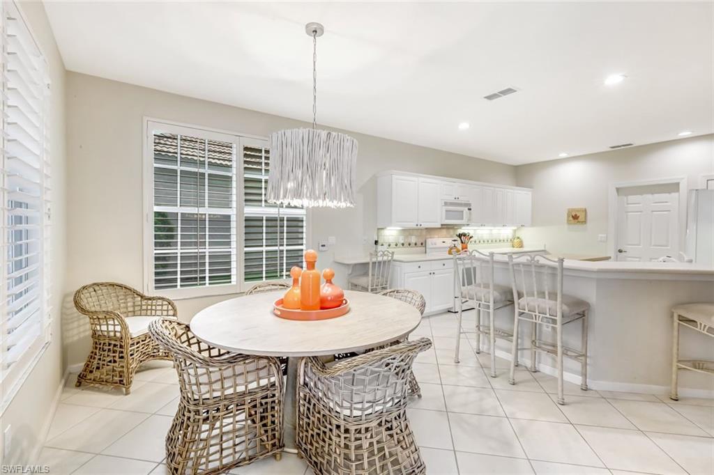 23045 Tree Crest Court Estero, FL 34135 - Photo 9 of 46 Dining Room with plantation shutters and beautifully designed chandelier.