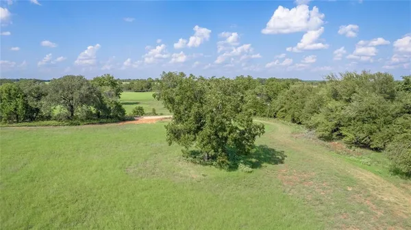 a view of a big yard with a house in the background