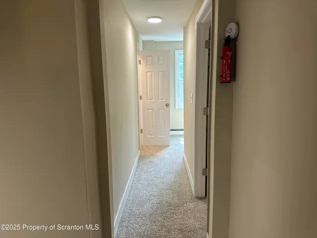 a view of a hallway with wooden shelves