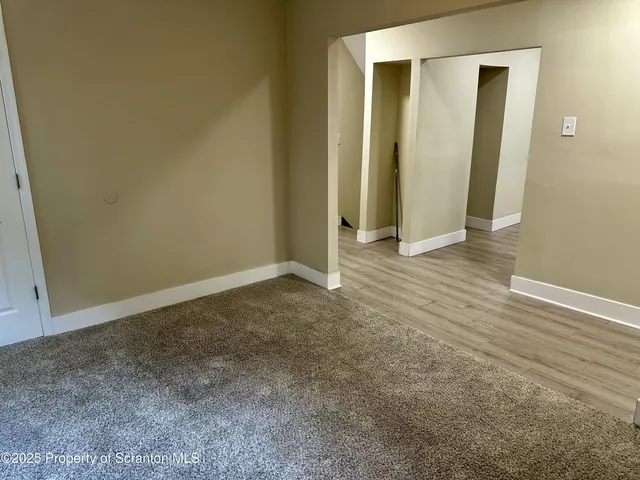 an empty room with wooden floor and a window