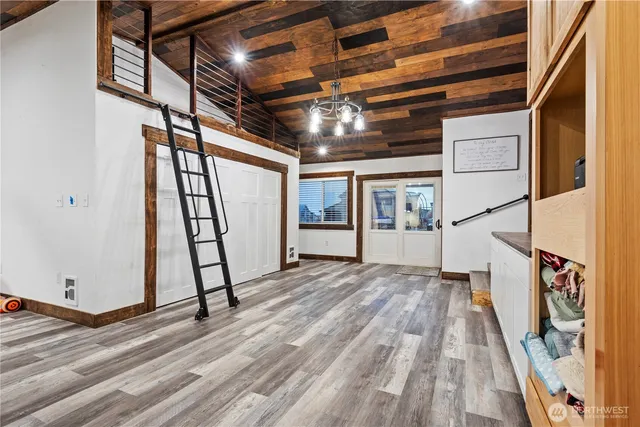 a view of an empty room with wooden floor and stairs