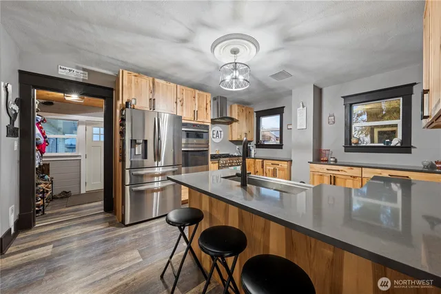 a kitchen with stainless steel appliances granite countertop a sink a stove and refrigerator