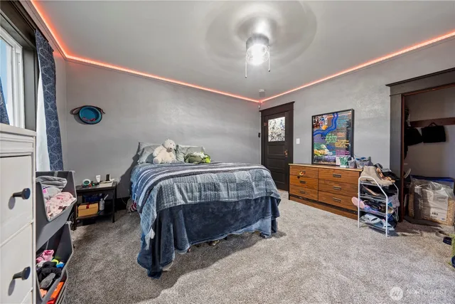 a bedroom with a bed and a flat tv screen on dresser