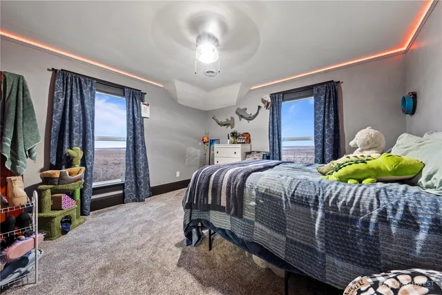 a bedroom with a bed and a flat tv screen on dresser