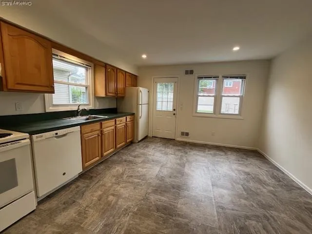 a kitchen with granite countertop a stove sink and cabinets