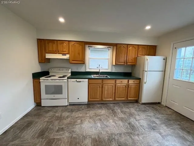a kitchen with a stove a refrigerator and a sink