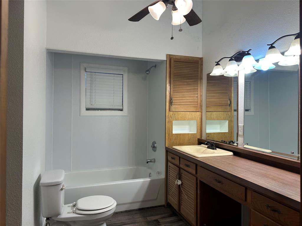 604 Harrel Avenue Bynum, TX 76631 - Photo 19 of 24 a bathroom with a sink a toilet and a bathtub