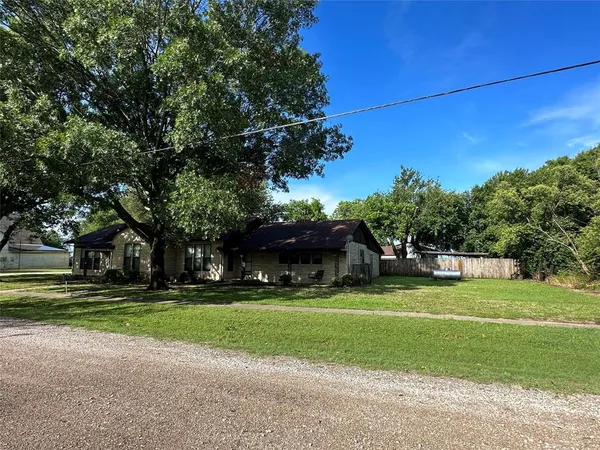 a front view of a house with a yard and trees