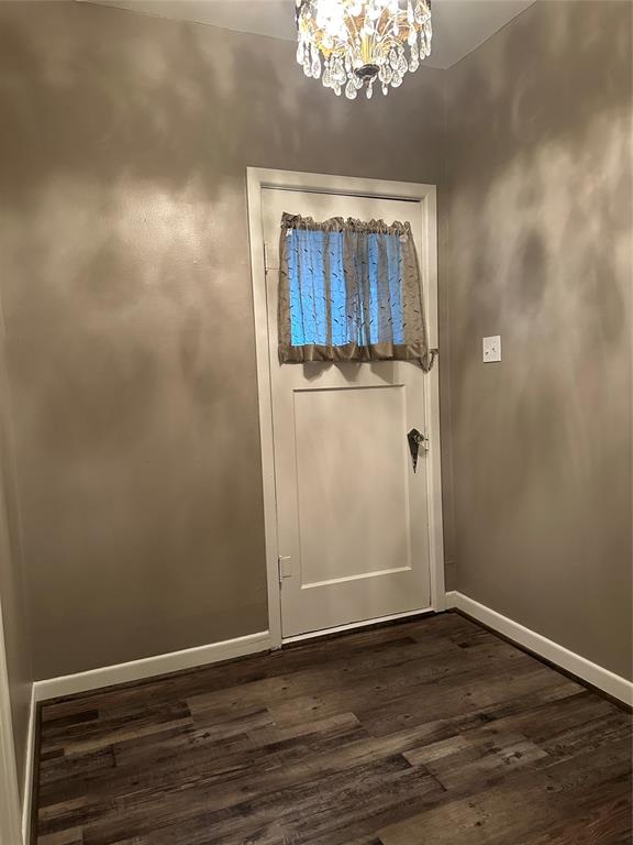 604 Harrel Avenue Bynum, TX 76631 - Photo 9 of 24 a view of a hallway with wooden floor and a chandelier