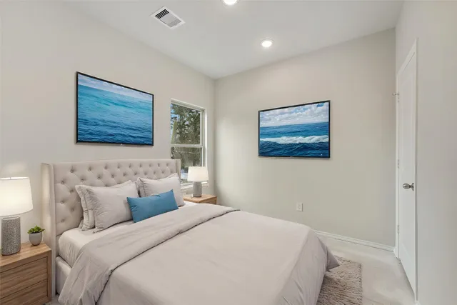 a bedroom with a bed and a painting on the wall